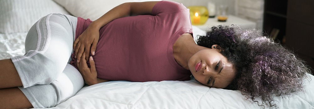 Woman with period cramps laying down