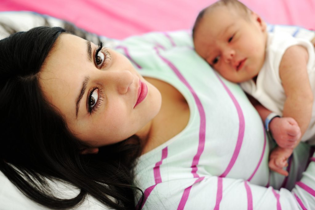 Woman holding baby while laying down