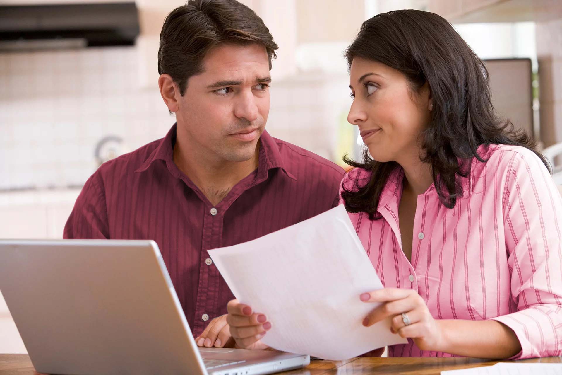 Man and woman looking at each other in front of laptop